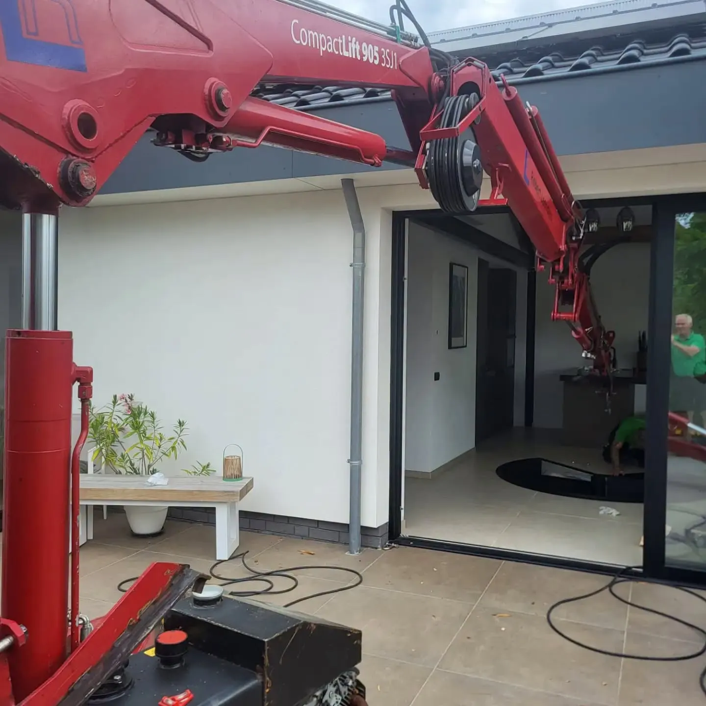 De Hoeflon C905 compact hijskraan plaatst de stalen spiltrap.
