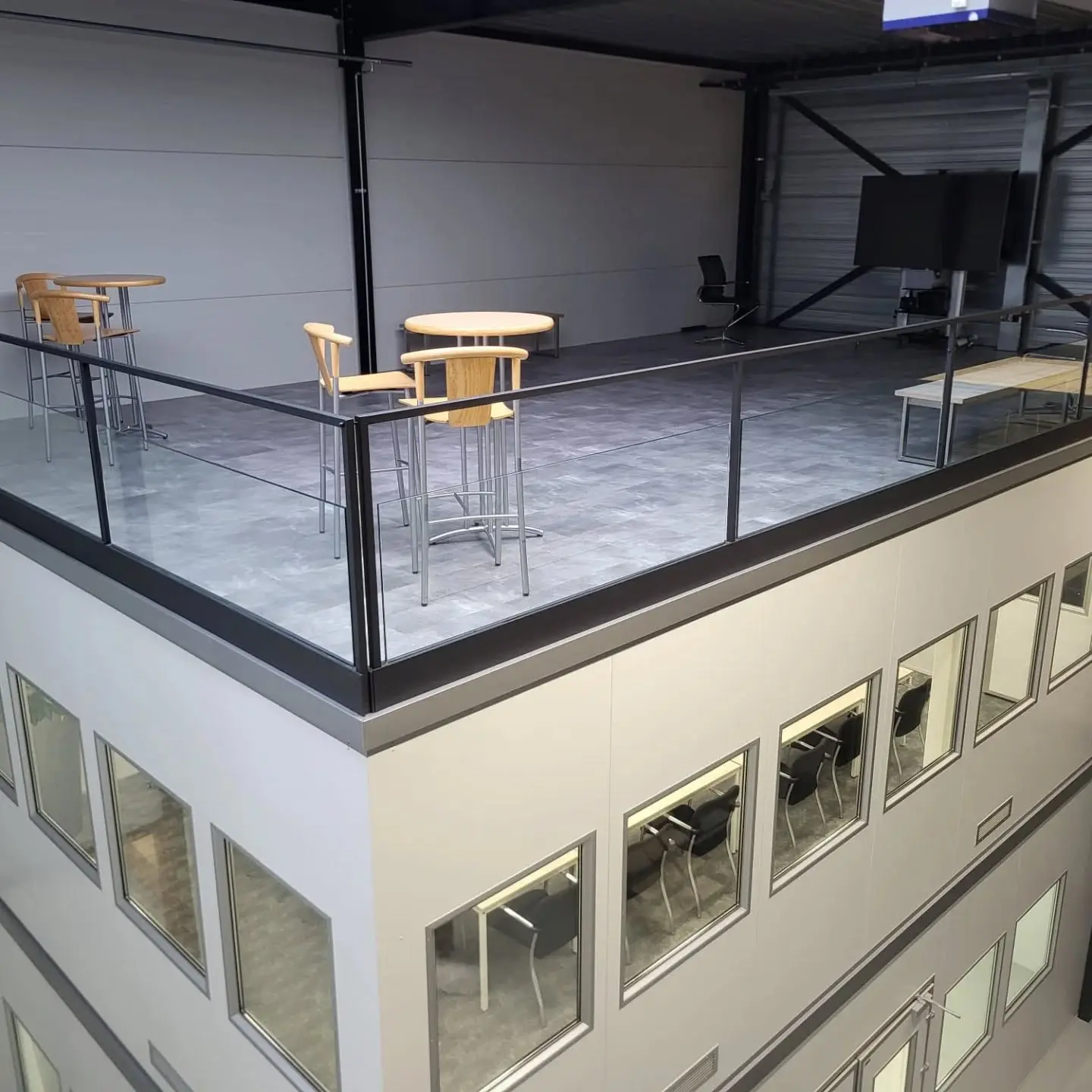 Project in Eindhoven met glasbalustrade in stalen klemprofiel, de stalen bordestrappen met houten treden zijn al eerder gerealiseerd. Bovenaanzicht in detail.