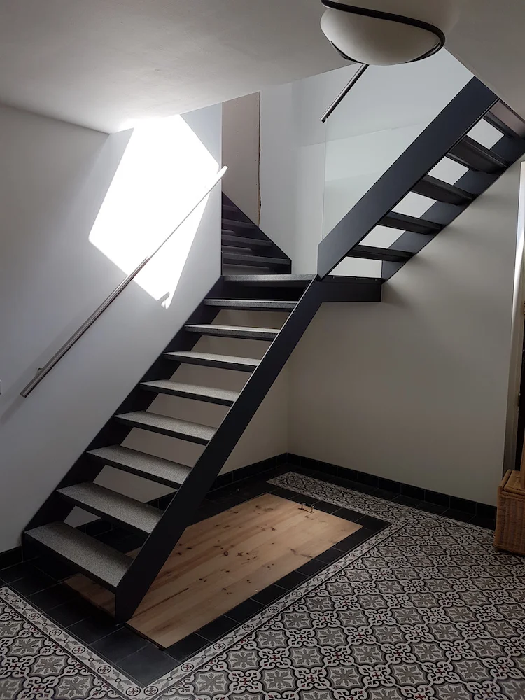 zwarte stalen trap met rvs leuningen